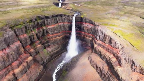 Aerial view of Hengifoss waterfall in serene landscape, Iceland.