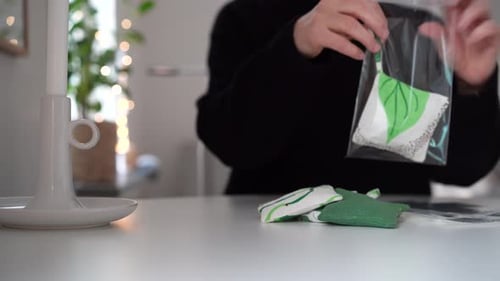 Una mujer en la mesa pone bolsas de lavanda en bolsas de celofán como regalos de Navidad