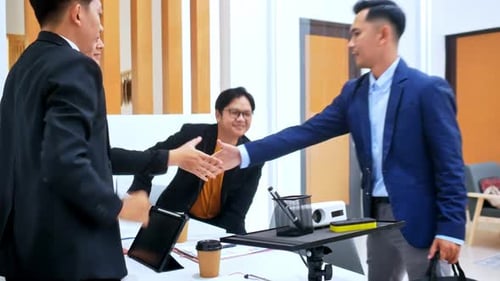 Diverse business team shakes hands before meeting in modern office