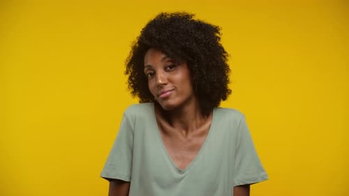 Young Woman Posing Confidently on Yellow Background
