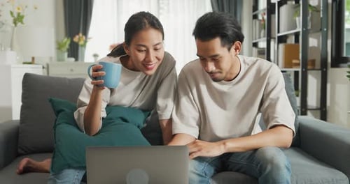 Couple Laughing at Laptop at Home Together