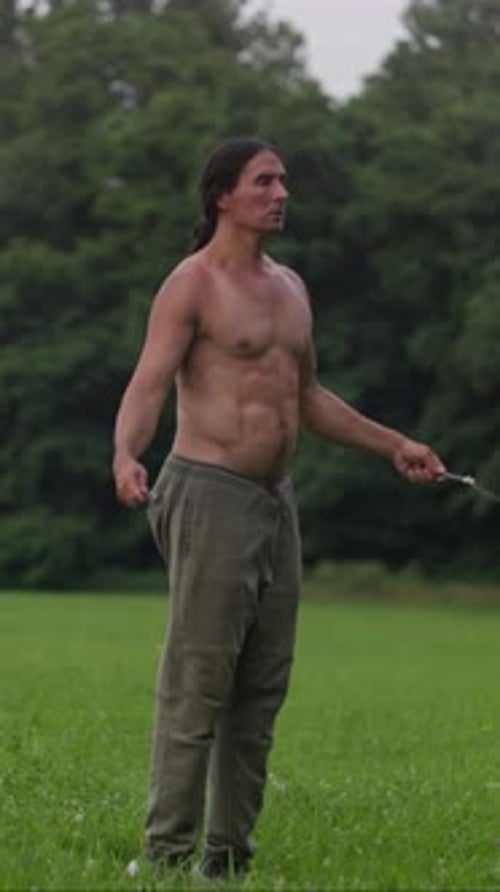 A Person Joyfully Jumping Rope in a Vibrant Green Field Showcasing Fitness and Exercise