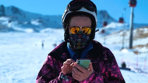 Young Adult Using Mobile Phone on Snowy Mountain