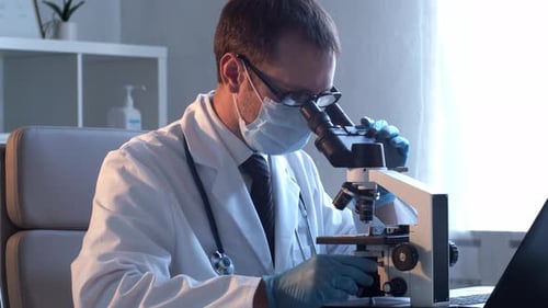 Scientist Uses Microscope in Bright Laboratory Setting