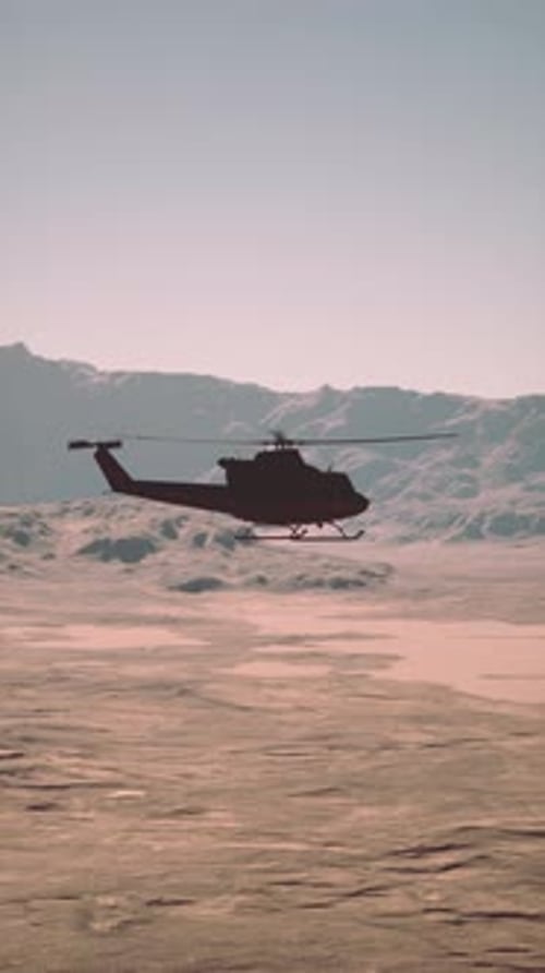 Military Helicopter Flying Over Desert With Mountains