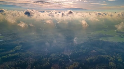 Cloudscape blowing in the atmosphere above a countryside forest - drone timelapse