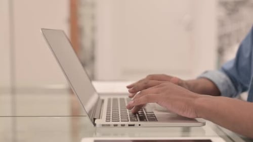 Side View of African Man Working on Laptop