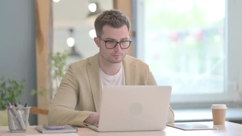 Man Working on Laptop in Modern Office