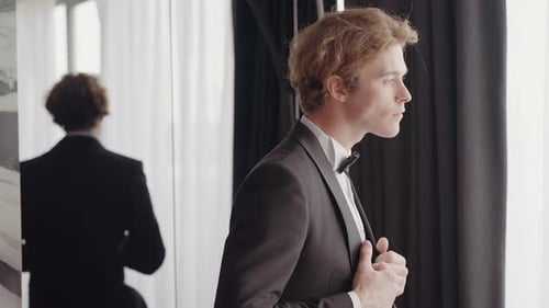 Groom Adjusting Tuxedo Before Wedding