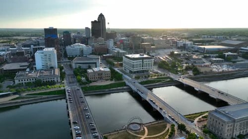 Wide aerial shot of Des Moines, IA during sunset. Reveal of capital city of Iowa skyline and river.