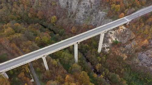 Aerial view of big viaduct of highway over the river in the mountain at autumn