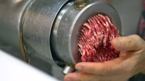 Fresh Meat Being Ground in a Local Butcher Shop