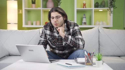 Young man working at home alone muttering to himself.