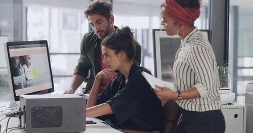 4k video footage of a group of young businesspeople using a computer together in a modern office