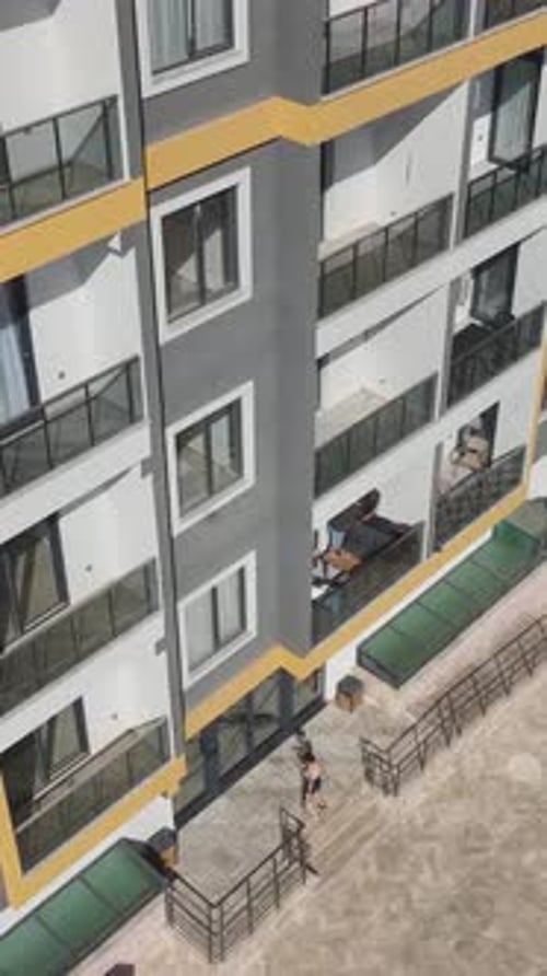 Vídeo vertical: trabajadores de la construcción que operan con elementos de piedra, marcos metálicos e instalación de fachadas