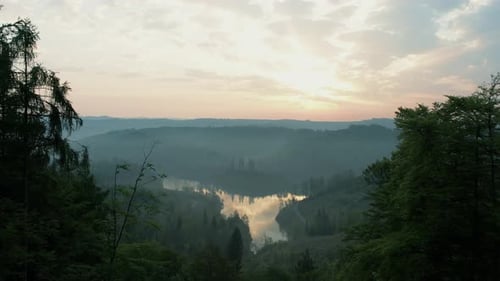 Serene Drone Flight At Sunset over Mountain Lake