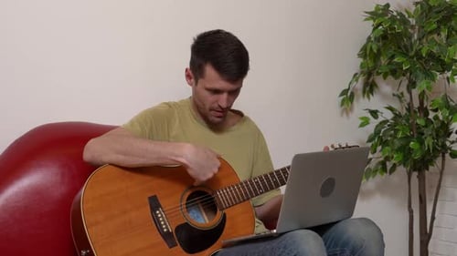 Man Giving Guitar Lesson Online via Video Chat