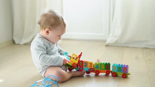 Adorable Infant Playing with Colorful Toy Train