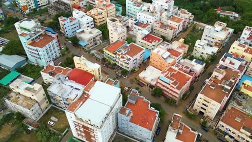 Residential district shops and orange open roof tops of Tiruchirappalli, city establishing aerial ov
