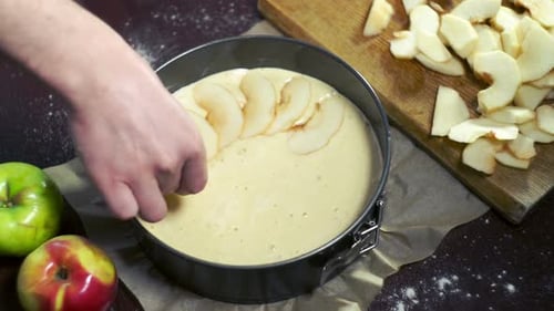 Hand Arranges Apple Slices in Cake Batter