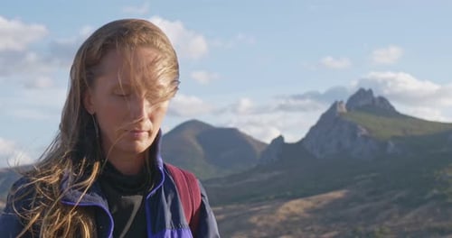 Woman Standing in the Mountains on a Sunny Day