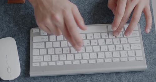 Top View Closeup of Male Hands Typing with Modern Wireless Keyboard While Man Working with Computer