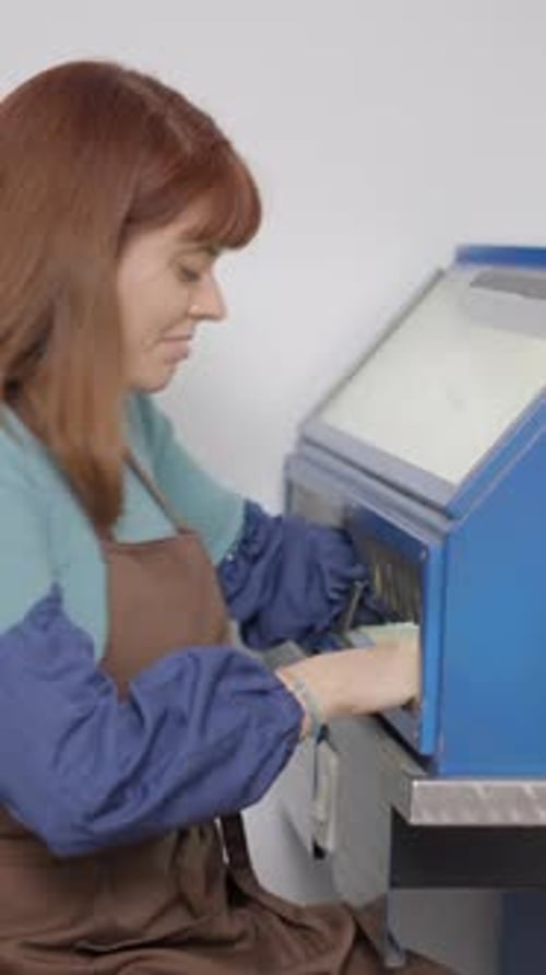 Skilled Jeweler Polishing An Accessory For Pet In Enclosed Grinding Table Polisher Closeup Sideview