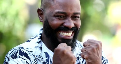 Man Cheering With Excitement and Smiling Outdoors