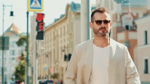 Stylish Man Walking Down City Street on Sunny Day