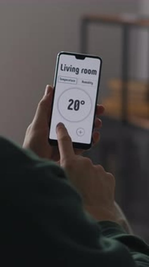 Man Using Home Automation App on Smartphone Indoors