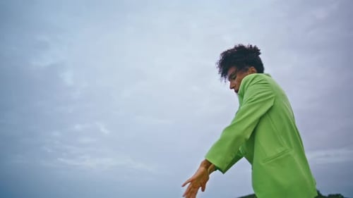 Young Adult Dancing Outdoors in Green Suit