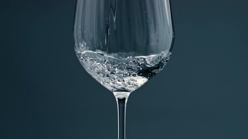 Clear Water Filling Cup Closeup. Pure Refreshing Beverage Pour Into Transparent Glass