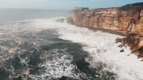 Massive Atlantic Waves Crashing Against The Famous High Nazare Cliffs
