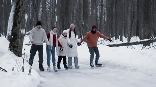 Large Young Family is Skating in Park Holding Hands Tightly and Inseparably They are Supporting Each