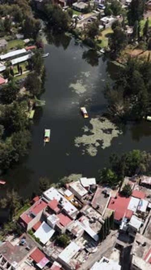 Capture aérienne en mode vertical des trajineras de Xochimilco par un après-midi ensoleillé. CDMX