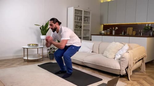 Tutorial de observación de ejercicios con un hombre haciendo sentadillas con pasos laterales en la computadora