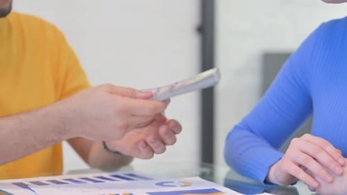 Close up of Man Paying Cash to Female Partner