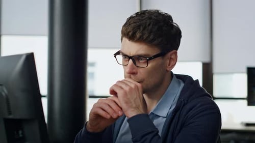Fokussierter Manager, Bildschirm am Arbeitsplatz, Nahaufnahme, seriöser Programmierer, der analysiert