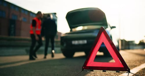 Adults Inspecting Disabled Car on Urban Roadside