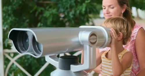 Child and Adult Using Coin Operated Viewing Binoculars