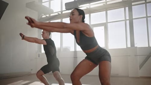 Closeup Side View of Young Fitness Coaches Exercising Doing Lunges with Outstretched Hands Forward