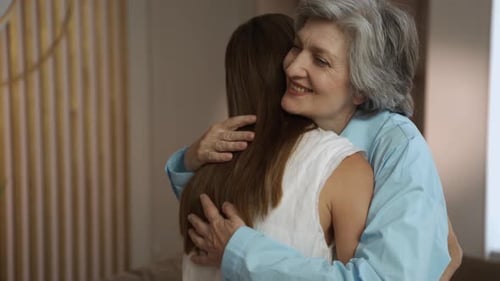 Loving Grandmother and Granddaughter Embrace Tenderly at Home