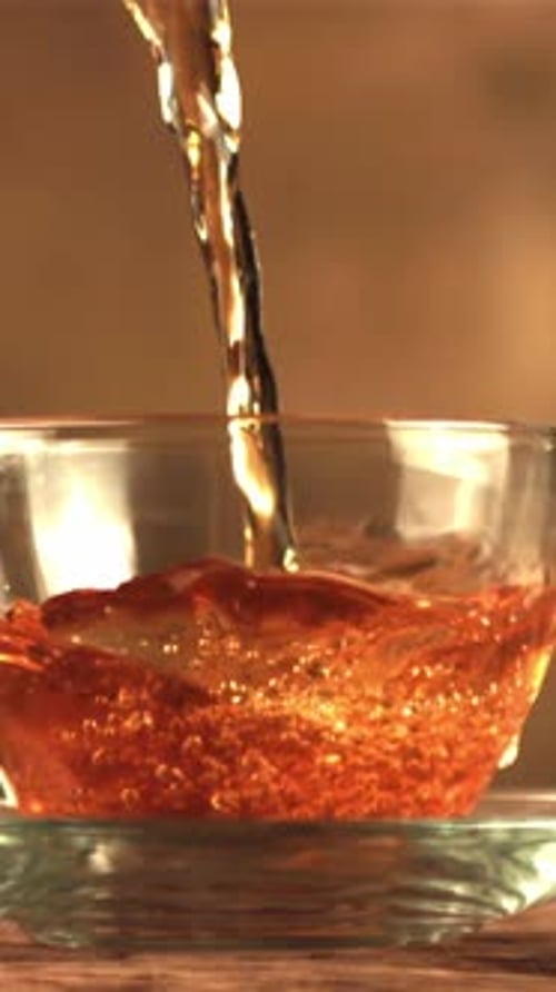 Un jet de thé au ralenti se déverse dans une tasse de bulles d'air filmées par une caméra à haute vitesse à 10h00