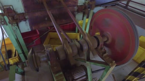 Machine with a spinning red wheel and moving parts