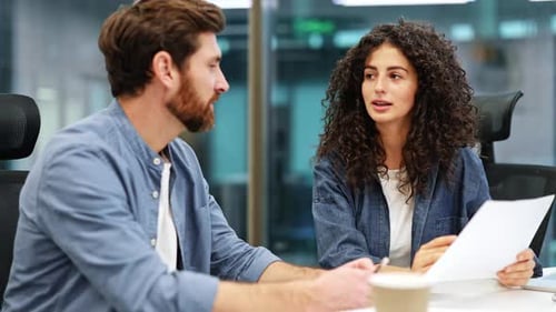 Businesspeople Shaking Hands After Signing Contract in Modern Office