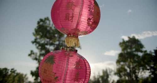 The red Chinese lanterns hanging in front of the gate of Chinese temple are swaying in the wind