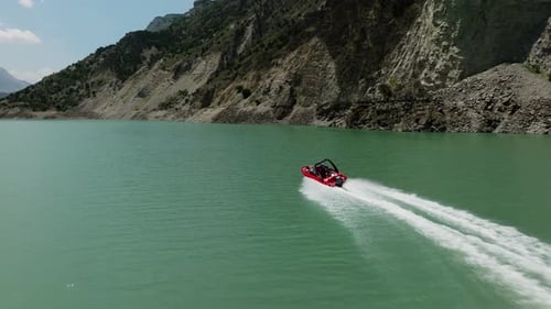 Powerboat Speeds Across Turquoise Lake in Mountains