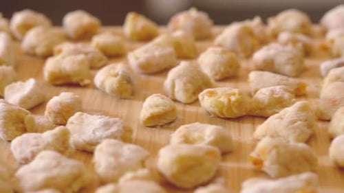 Stabile Kamera auf einem Schneidebrett voller Gnocchi, fertig zum Kochen