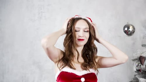 Woman in Santa Dress Dancing Near Christmas Tree