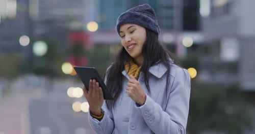 Woman Video Chatting on Tablet in City